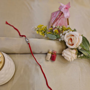 Red string with a small decorative item on a beige background