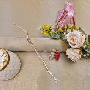 Decorative item with flowers, small bottles, and a ceramic piece on a beige background